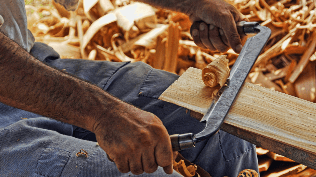 a person is working on a piece of wood with a saw