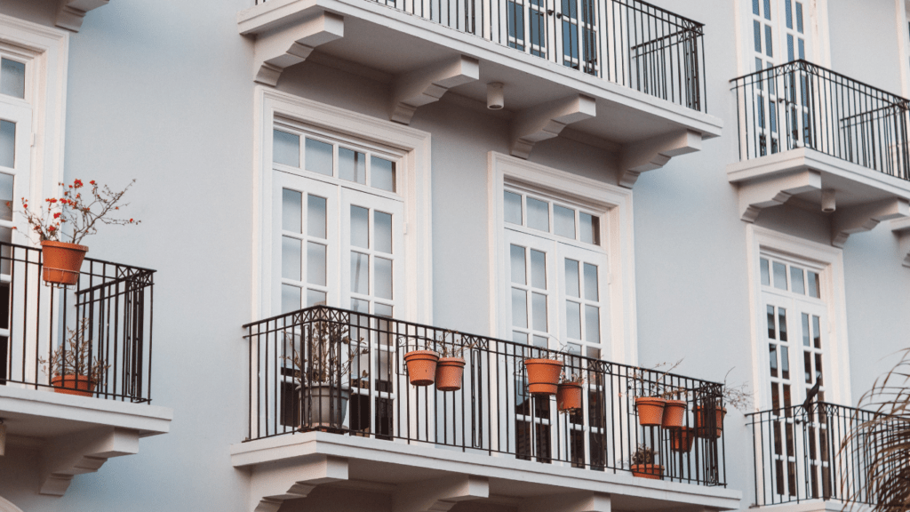 an apartment building with balconies and potted plants