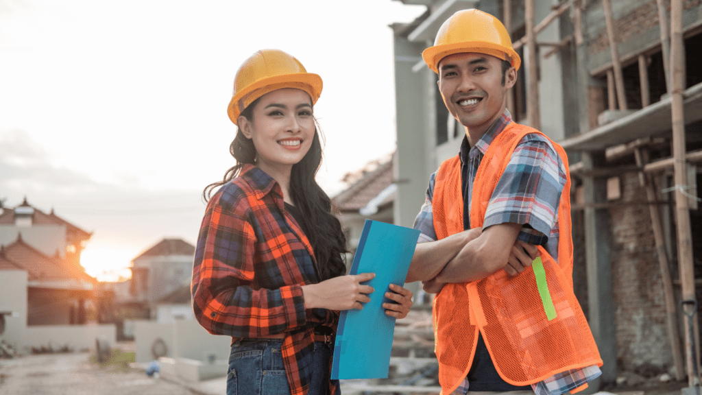 Two people in hard hats standing in front of a construction site