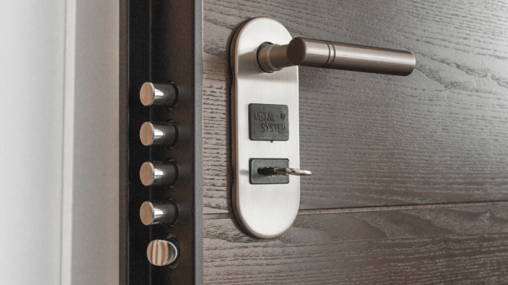 a close up of a metal door handle on a wooden door