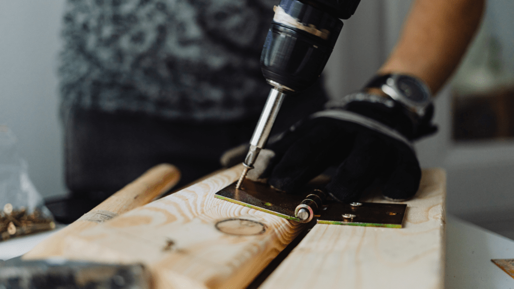 a person using a cordless drill on a wooden floor